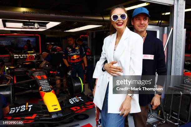 Maria Sharapova and Alexander Gilkes pose for a photo next to the car of Sergio Perez of Mexico and Oracle Red Bull Racing in the garage during the...