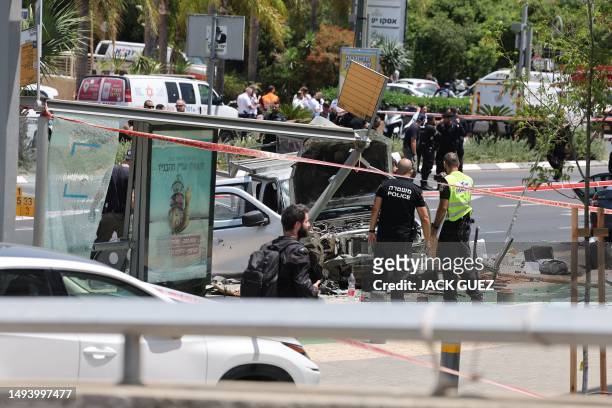Israeli security and emergency personnel work at the site of a reported car ramming attack in Tel Aviv on July 4, 2023. The suspected attack has...