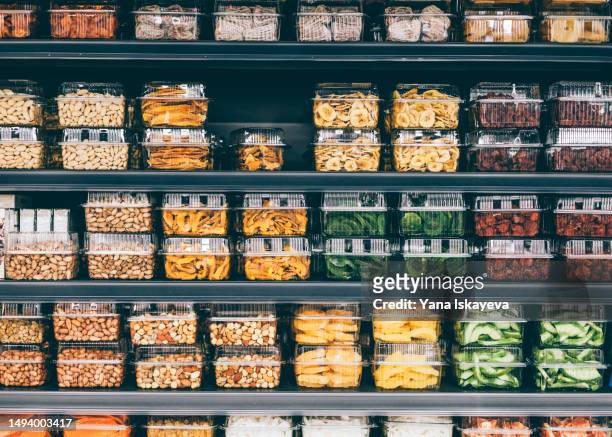 store shelves with dried fruit, veggies, and nuts in a non-ecological packaging - storage room stock-fotos und bilder