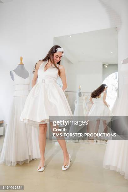 young and beautiful woman is trying on a wedding dress  in a wedding boutique - tailor - bridal shop stock pictures, royalty-free photos & images