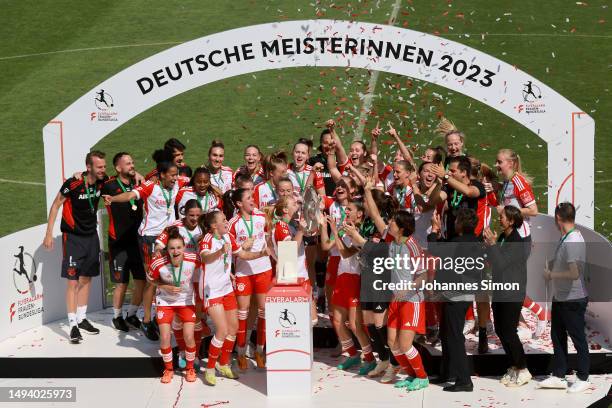 Lea Schueller of FC Bayern Munich lifts the Frauen-Bundesliga trophy after their team's victory in the FLYERALARM Frauen-Bundesliga match between FC...