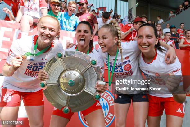 Lea Schueller, Jovana Damnjanovic, Giulia Gwinn and Ivana Rudelic of FC Bayern Munich celebrate with the FLYERALARM Frauen-Bundesliga trophy...