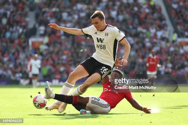 Joao Palhinha of Fulham is tackled by Tyrell Malacia of Manchester United during the Premier League match between Manchester United and Fulham FC at...
