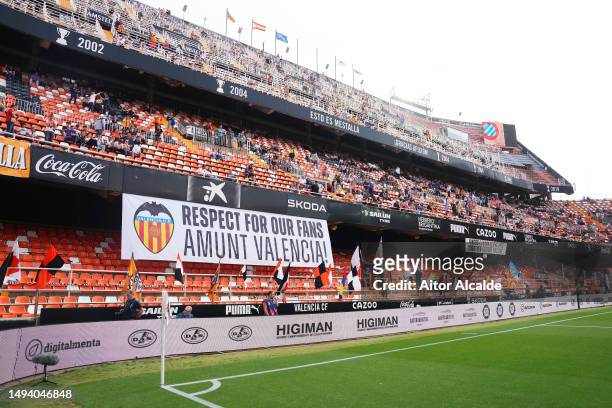 Empty seats are seen inside the stadium where a banner reads "Respect for our fans, Amunt Valencia!" prior to the LaLiga Santander match between...