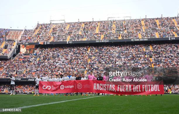 Players from both teams and match officials pose for a photo with a banner against racism prior to the LaLiga Santander match between Valencia CF and...