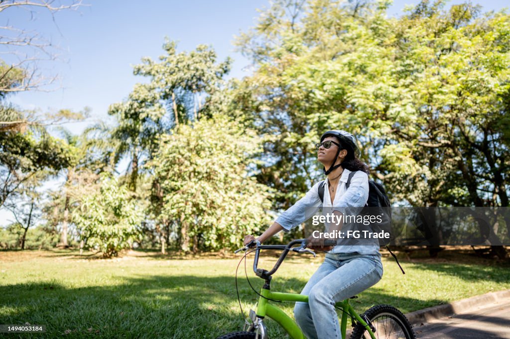Femme d’affaires faisant du vélo dans le parc public