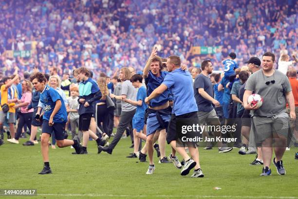 Fans of Everton invade the pitch and celebrate after their sides victory, which secures their position in the Premier League next season, in the...