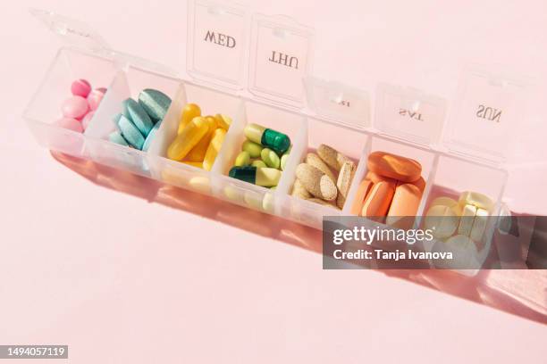 box for pills and capsules on pink background. pills organizer. - contenitore organizer per pillole foto e immagini stock