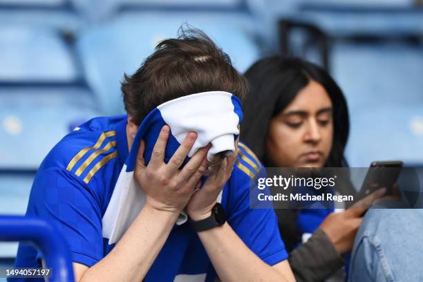 Leicester City fan looks dejected after their sides defeat, resulting in their relegation to the Championship during the Premier League match between...