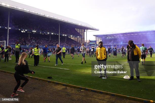 Fans of Everton invade the pitch and celebrate after their sides victory, which secures their position in the Premier League next season, in the...