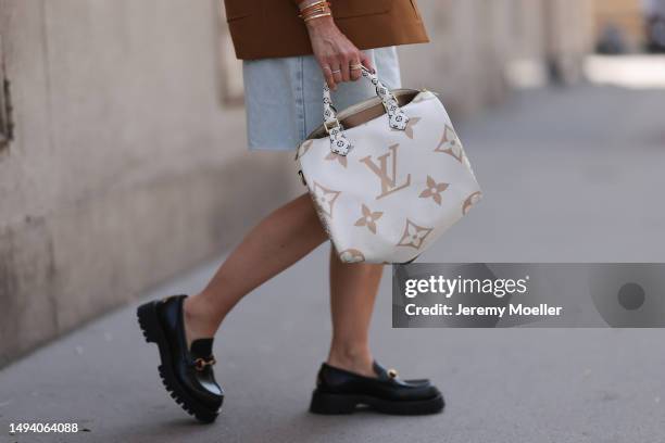 Karin Teigl wearing Gucci black leather loafer, Louis Vuitton beige brown speedy bag, Prada logo white linen logo bra top and Prada brown blazer...