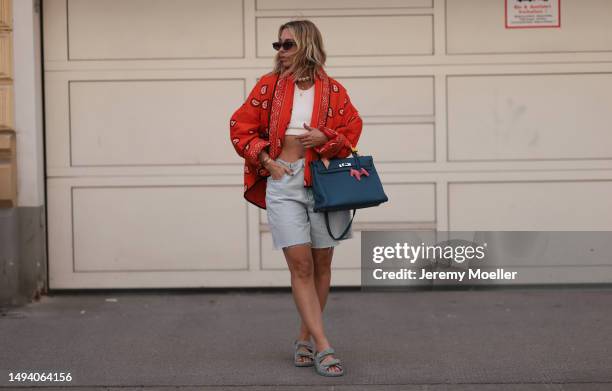 Karin Teigl wearing Valentino shades, Zara jeans shorts, CYK white cropped bra top, Hermes blue leather Kelly bag, Chanel denim sandals, Julia...