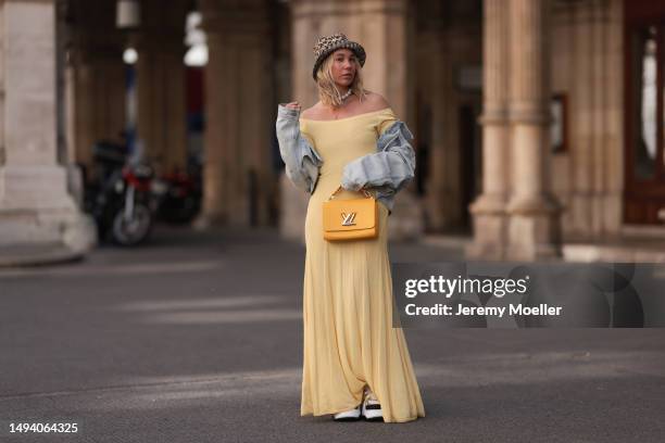 Karin Teigl wearing Louis Vuitton Archlight 2.0 white statement sneaker, Jacquemus yellow long cotton dress, The Attire cropped light blue jeans...