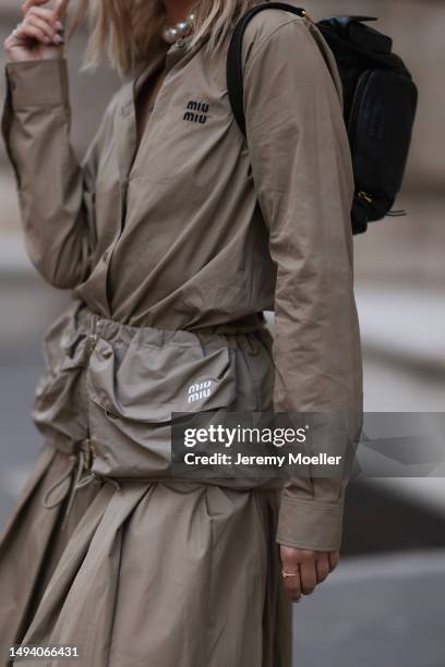 Karin Teigl wearing Miu Miu earth tones logo flannel, Miu Miu matching midi skirt, Miu Miu Pocket belt, Miu Miu Pocket black leather bag, Miu Miu...