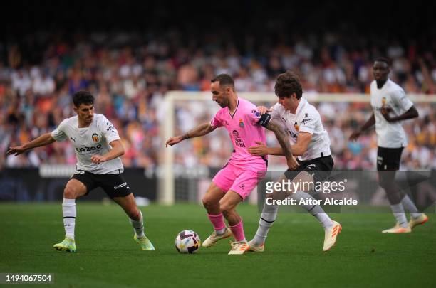 Sergi Darder of RCD Espanyol is put under pressure by Andre Almeida and Javi Guerra of Valencia CF during the LaLiga Santander match between Valencia...