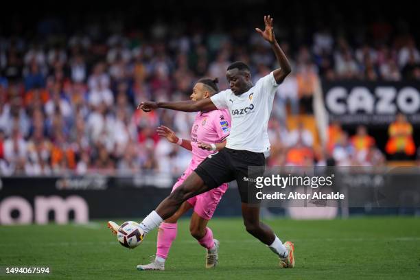 Mouctar Diakhaby of Valencia CF battles for possession with Martin Braithwaite of RCD Espanyol during the LaLiga Santander match between Valencia CF...