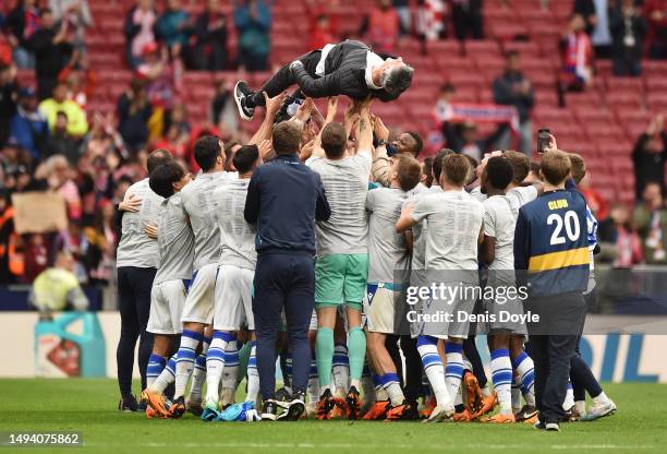 Real Sociedad players lift up Imanol Alguacil, Head Coach of Real Sociedad, as they celebrate the team's victory and qualify for the UEFA Champions...