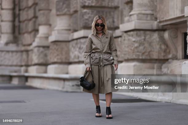 Karin Teigl wearing Miu Miu earth tones logo flannel, Miu Miu matching midi skirt, Miu Miu Pocket belt, Miu Miu Pocket black leather bag, Miu Miu...