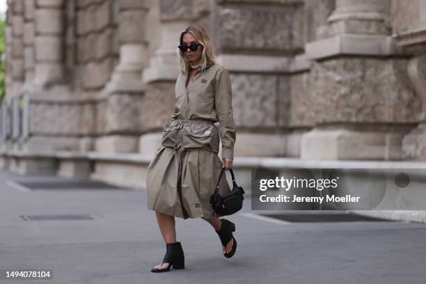 Karin Teigl wearing Miu Miu earth tones logo flannel, Miu Miu matching midi skirt, Miu Miu Pocket belt, Miu Miu Pocket black leather bag, Miu Miu...