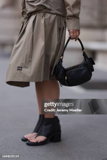 Karin Teigl wearing Miu Miu earth tones logo flannel, Miu Miu matching midi skirt, Miu Miu Pocket belt, Miu Miu Pocket black leather bag, Miu Miu...