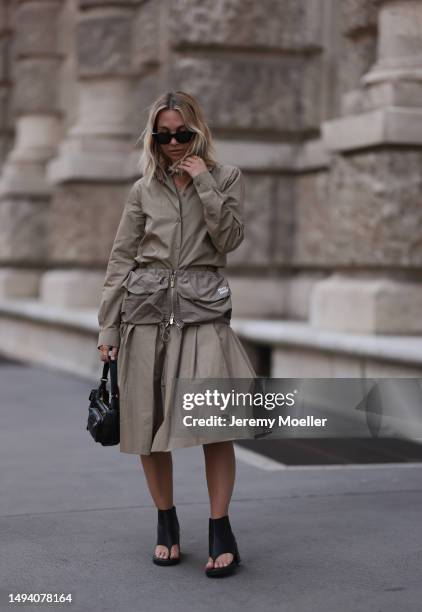 Karin Teigl wearing Miu Miu earth tones logo flannel, Miu Miu matching midi skirt, Miu Miu Pocket belt, Miu Miu Pocket black leather bag, Miu Miu...