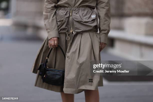 Karin Teigl wearing Miu Miu earth tones logo flannel, Miu Miu matching midi skirt, Miu Miu Pocket belt, Miu Miu Pocket black leather bag, Miu Miu...