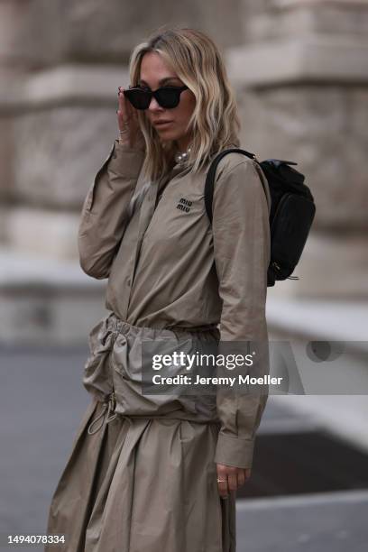 Karin Teigl wearing Miu Miu earth tones logo flannel, Miu Miu matching midi skirt, Miu Miu Pocket belt, Miu Miu Pocket black leather bag, Miu Miu...