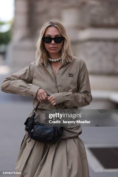 Karin Teigl wearing Miu Miu earth tones logo flannel, Miu Miu matching midi skirt, Miu Miu Pocket belt, Miu Miu Pocket black leather bag, Miu Miu...