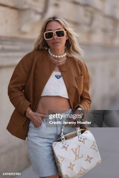 Karin Teigl wearing Gucci black leather loafer, Louis Vuitton beige brown speedy bag, Prada logo white linen logo bra top and Prada brown blazer...