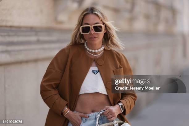 Karin Teigl wearing Gucci black leather loafer, Louis Vuitton beige brown speedy bag, Prada logo white linen logo bra top and Prada brown blazer...