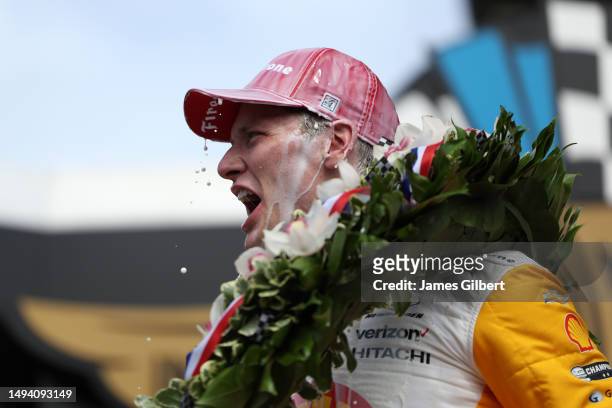 Josef Newgarden, driver of the PPG Team Penske Chevrolet, celebrates by pouring milk on his head after winning the 107th Running of Indianapolis 500...