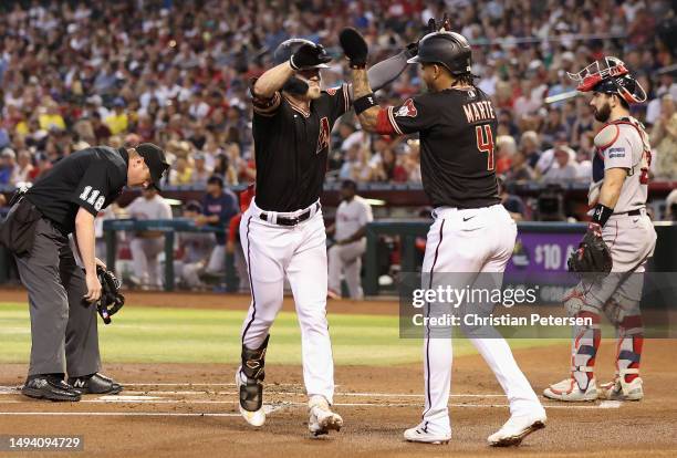 Corbin Carroll of the Arizona Diamondbacks high fives Ketel Marte after hitting a two-run home run against the Boston Red Sox during the second...