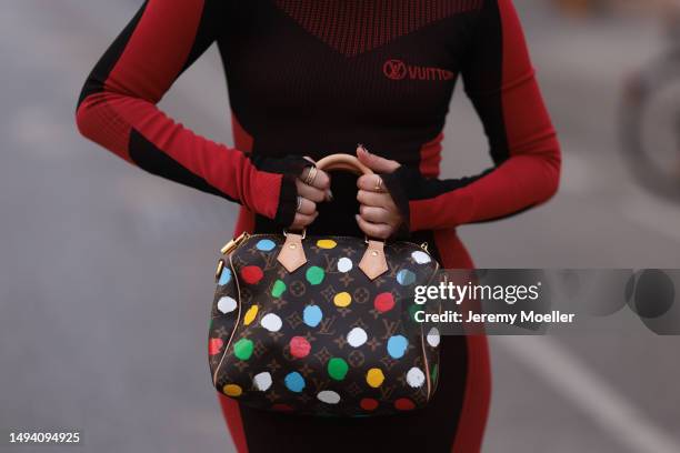 Karin Teigl wearing Louis Vuitton black rubber summer flats, Louis Vuitton x Yayoi Kusama logo monogram mini Speedy bag, Louis Vuitton red and black...