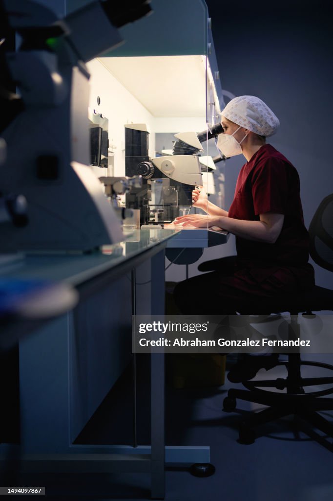 Woman sitting analyzing samples in a fertility laboratory