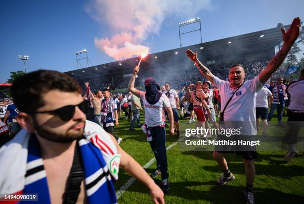 Hamburger SV fans celebrate with pyrotechnic flares after the team's victory, before 1. FC Heidenheim 1846 scored a last minute goal, to confirm...