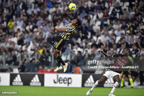 Juan Cuadrado of Juventus jumps for the ball against Rafael Leao of AC Milan during the Serie A match between Juventus and AC MIlan at Allianz...