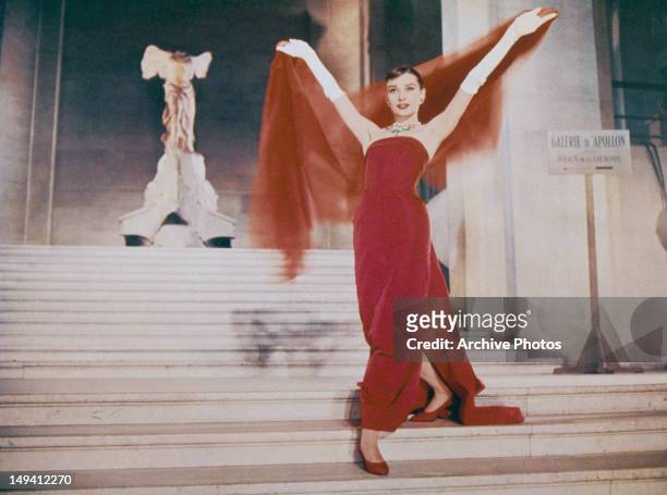 Actress Audrey Hepburn descends the Daru Staircase at the Louvre in Paris, in a scene from the film 'Funny Face', 1957. The ancient marble sculpture...