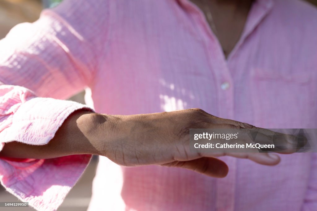 Black woman holds her hand to check for trembling