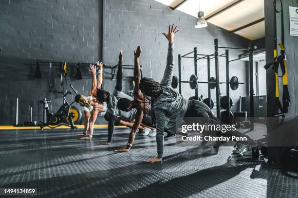 vista trasera de amigos trabajando en plancha lateral en el gimnasio - entrenamiento-sin-material fotografías e imágenes de stock