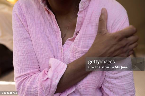 black woman experiences shoulder pain - doctor gripping stock pictures, royalty-free photos & images
