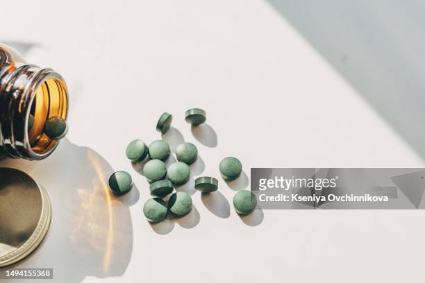 set of spirulina algae powder and pills on white background - protein powder stock-fotos und bilder