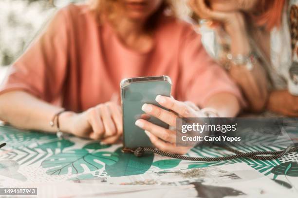 medium shot of two women using smartphone - ghosted stock pictures, royalty-free photos & images