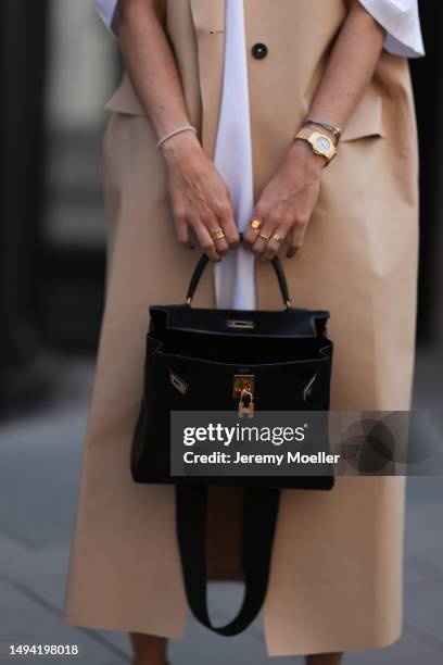 Kathrin Bommann wearing Kassel long beige vest coat, Vival Studio white oversized shirt dress, Saint Laurent black shades, Hermes vintage black...