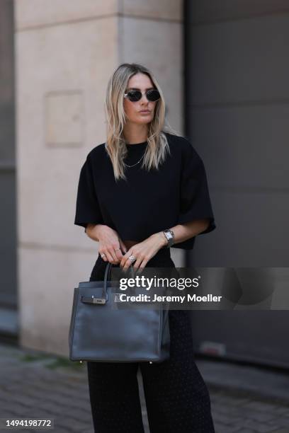 Kathrin Bommann wearing Chanel black wide leg logo denim pants, ALAÏA black mesh ballerina flats, Vival studio black cropped t shirt, Cartier tank...