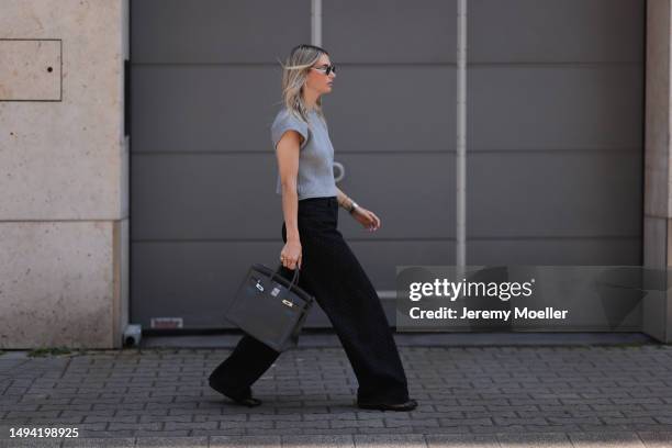 Kathrin Bommann wearing Chanel black wide leg logo denim pants, ALAÏA black mesh ballerina flats, Vival studio grey cropped backless top, Cartier...