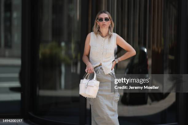 Kathrin Bommann wearing Adidas Yeezy beige rubber slides, Celine chrome silver oval shades, Chanel beige vest knit vintage top, Hermes Picotin beige...