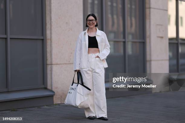 Maria Barteczko wearing ARKET white oversized linen shirt, H&M black crop top, Source Unknown off white denim baggy jeans, Stradivarius black studded...