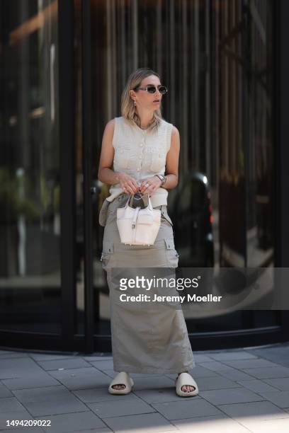 Kathrin Bommann wearing Adidas Yeezy beige rubber slides, Celine chrome silver oval shades, Chanel beige vest knit vintage top, Hermes Picotin beige...