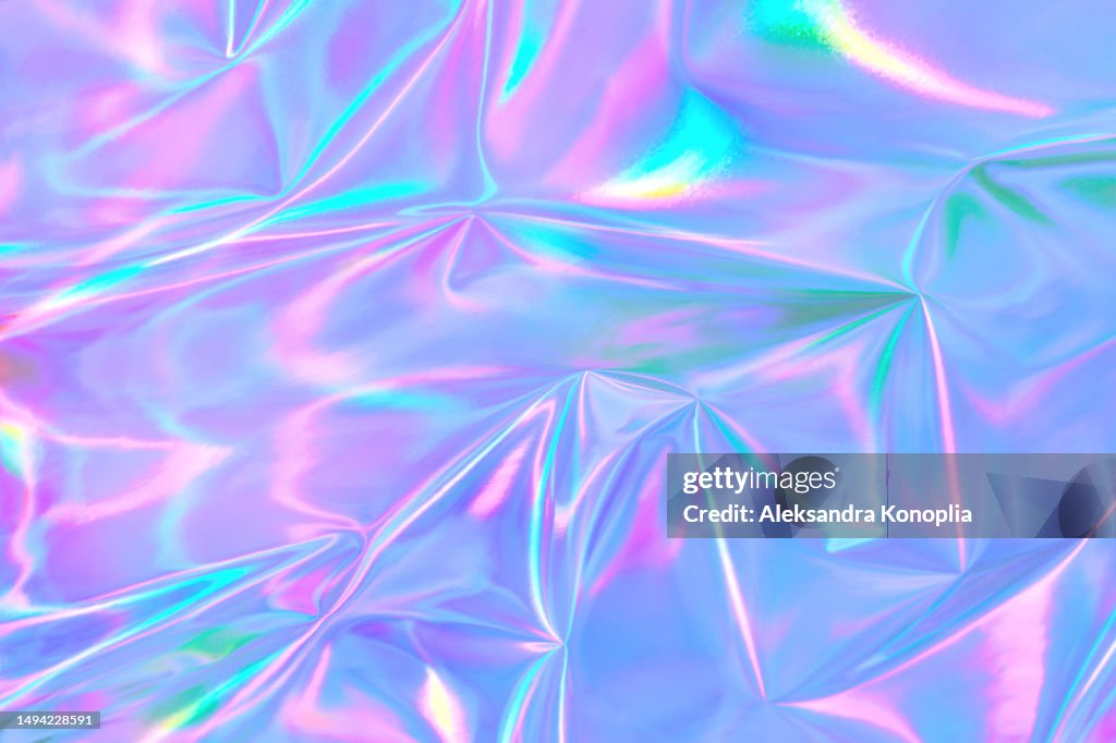 Abstract ethereal pastel neon holographic blue, pink, digital lavender purple crumpled metallic foil background.
