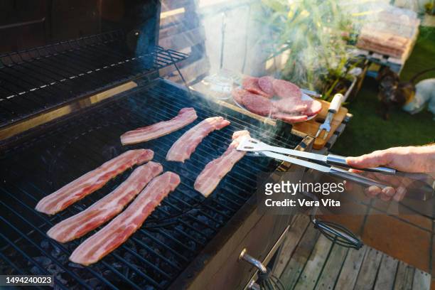 https://media.gettyimages.com/id/1494240023/photo/close-up-view-of-unrecognizable-man-grilling-bacon-using-tongs-at-spanish-barbecue-party.jpg?s=612x612&w=gi&k=20&c=HFwCrKOXEU0Rqc0BFrCnQbqFfQJu6fv89xfP4VUYLlg=